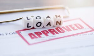 the word loan on dice and the word approved stamped on paper