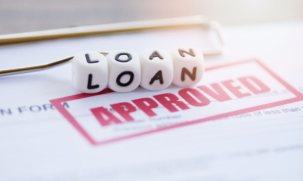the word loan on dice and the word approved stamped on paper