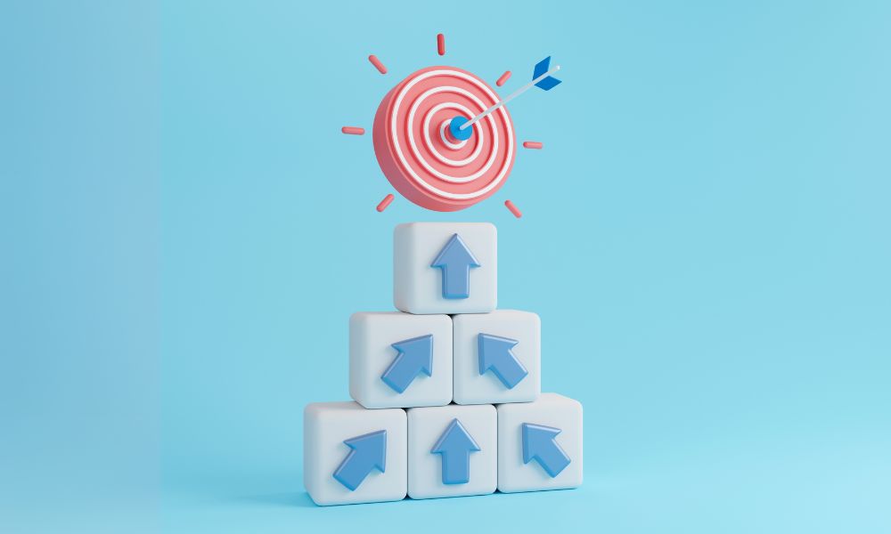 Arrows on building blocks leading to a target to represent achieving business goals.